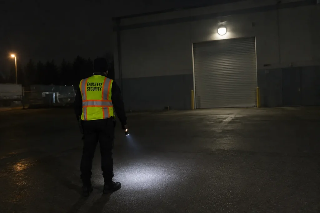 Security guard checking a warehouse loading yard at night